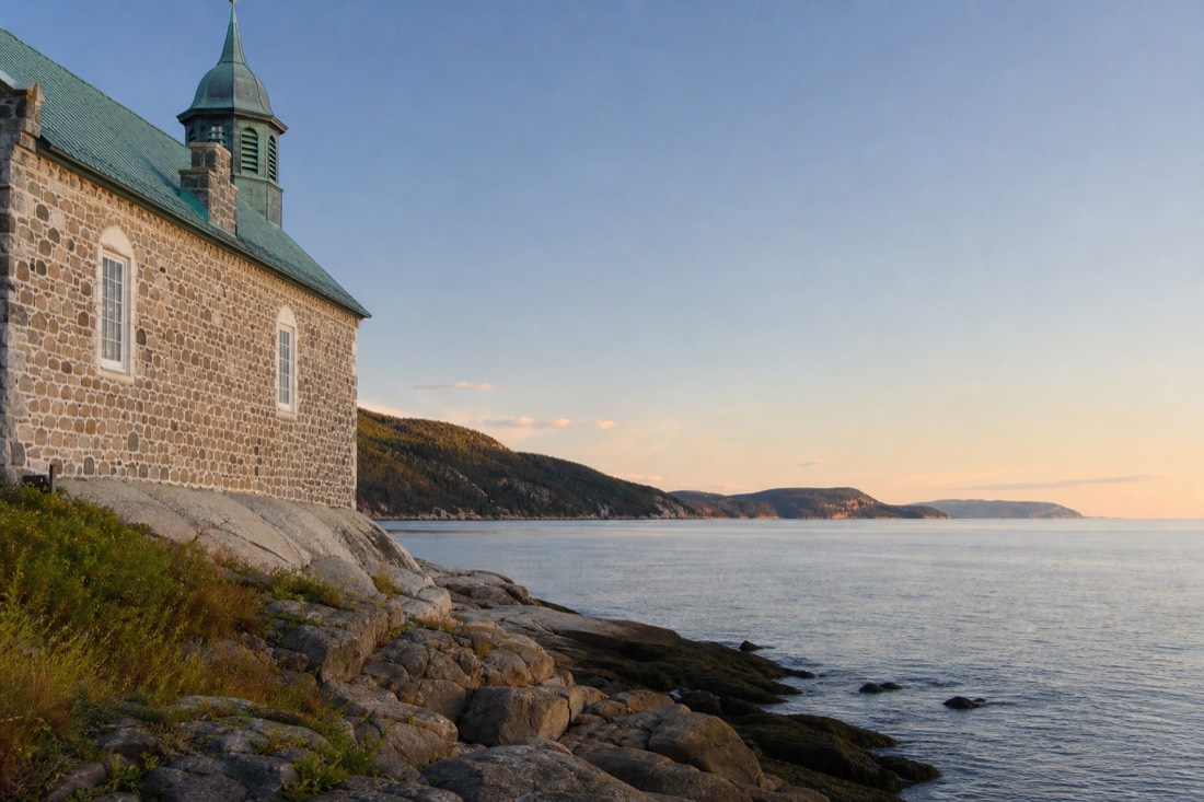Calm September water on the St. Lawrence estuary at Tadoussac with low sun and no boat traffic