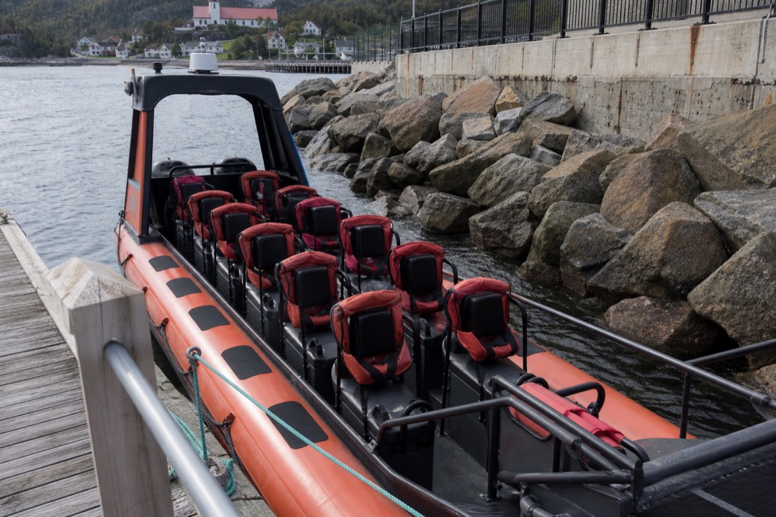 Empty zodiac boat moored at Tadoussac with flotation suits laid out on the bench seats