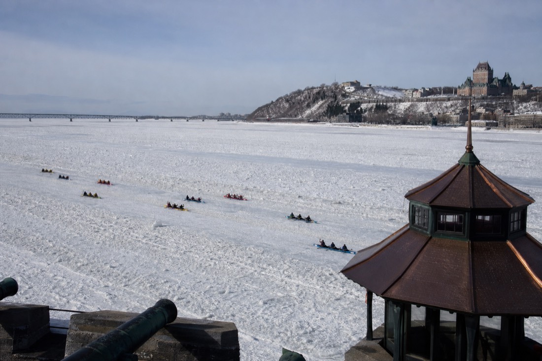 Ice canoe teams crossing the frozen St. Lawrence River during the Quebec Winter Carnival race