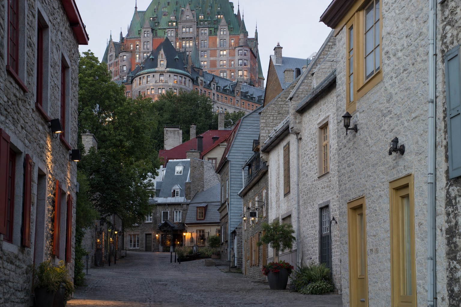 Cobbled Petit Champlain street with stone shopfronts beneath the Château Frontenac in evening light