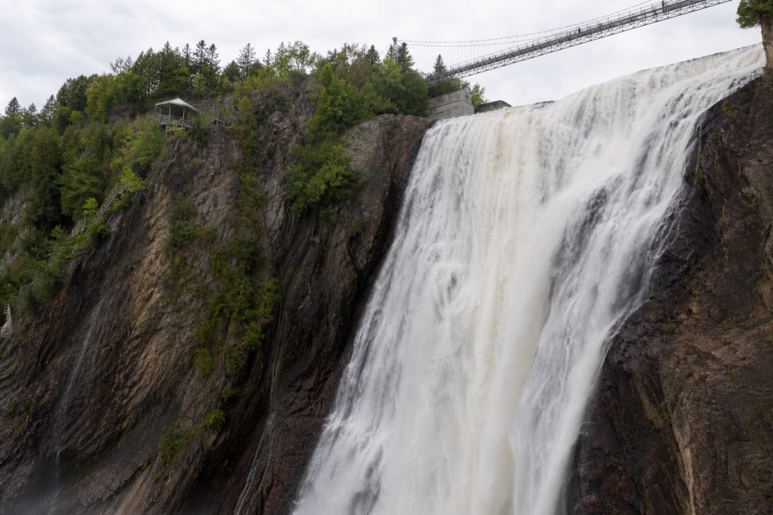 Montmorency Falls plunging past the cliffside boardwalk and suspension bridge near Quebec City