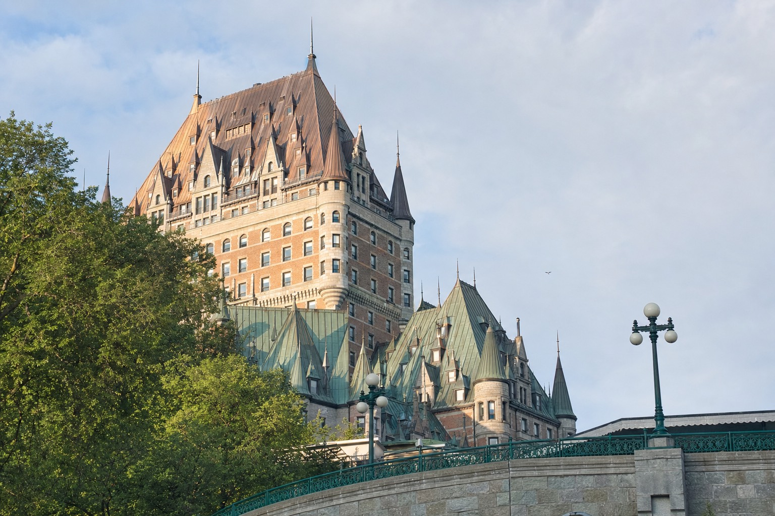 Copper turrets of the Château Frontenac rising above Dufferin Terrace in morning light