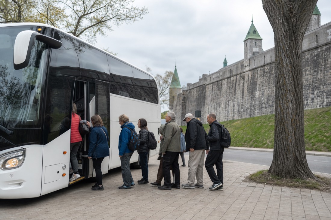 Tour coach parked near the old city walls of Quebec with passengers boarding