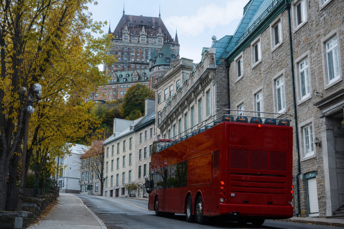 Open-top double-decker sightseeing bus climbing a street in Upper Town Quebec City