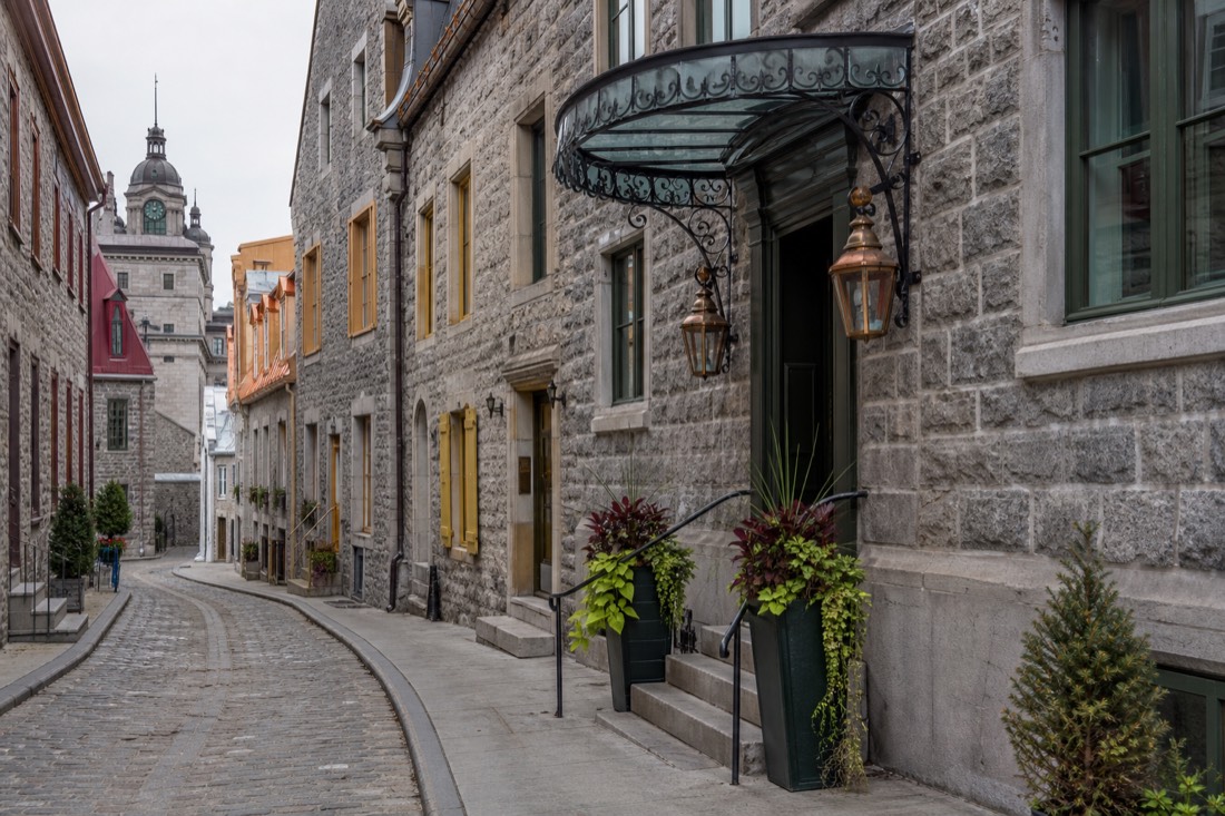 Stone facades and boutique hotel entrances along a narrow street in Old Quebec
