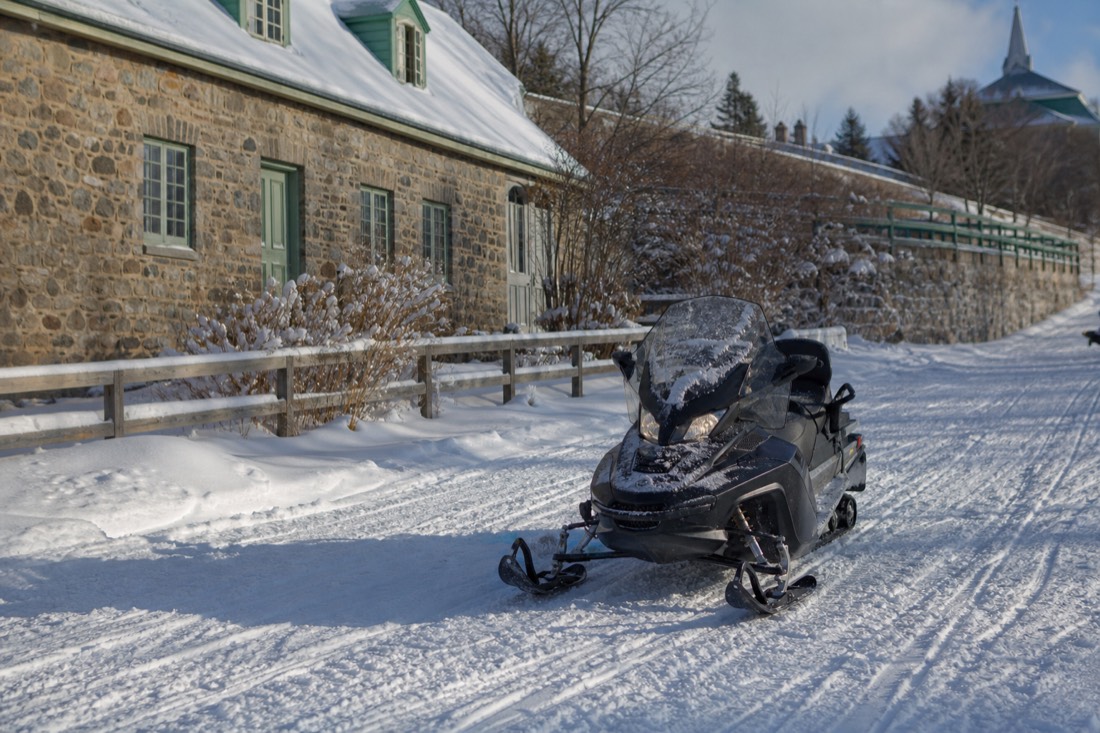 A snowmobile crossing a snowy trail on Île d'Orléans near Quebec City in deep winter